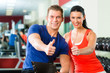 woman and Personal Trainer in gym, with dumbbells