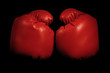 Vintage boxing gloves emerging from black background
