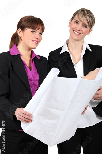Photo: Two women holding plans Two women holding plans