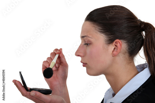 Photo: Businesswoman putting on makeup Businesswoman putting on makeup