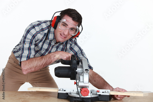 Photo: Man using a mitre saw Man using a mitre saw