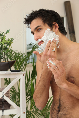 Photo: Young man applying shaving cream Young man applying shaving cream