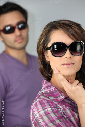 Photo: young woman and man wearing sunglasses young woman and man wearing sunglasses