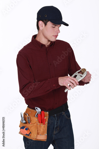 Photo: Plumber making adjustments to pipe with wrench Plumber making adjustments to pipe with wrench