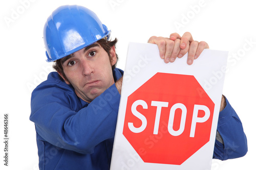 Photo: builder in jumpsuit holding stop sign builder in jumpsuit holding stop sign