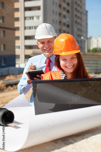 Photo: two builders works on the building site two builders works on the building site