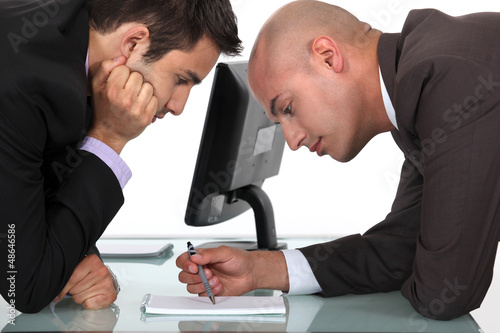 Photo: Businessmen looking through notes Businessmen looking through notes
