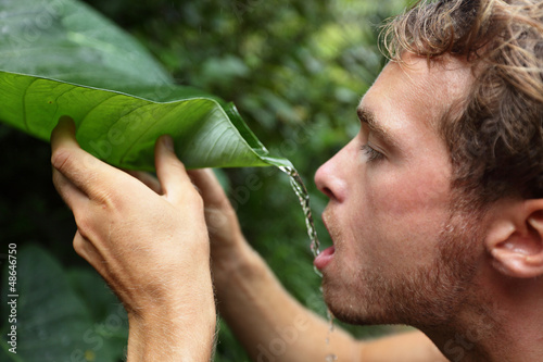 Photo: Survival - man drinking from leaf in jungle Survival - man drinking from leaf in jungle