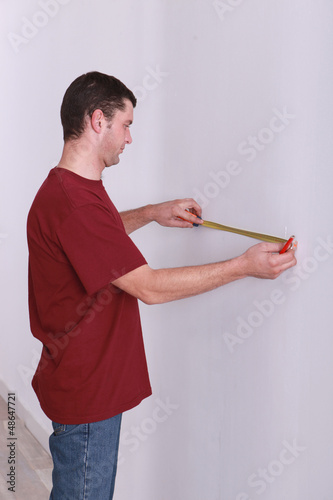 Photo: Man measuring wall Man measuring wall