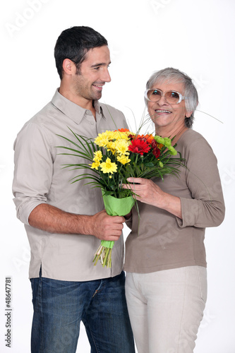 Photo: Son giving mother flowers Son giving mother flowers