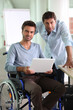 Man in wheelchair holding laptop