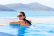 Foto: Young woman relaxing at swimming pool of Greece Young woman relaxing at swimming pool of Greece