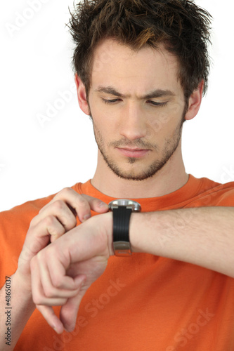 Photo: Man checking his wristwatch for the time Man checking his wristwatch for the time