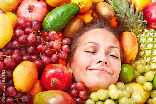 Photo: Happy girl in group of fruit. Happy girl in group of fruit.