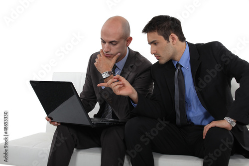 Photo: duo of businessman with laptop exchanging views duo of businessman with laptop exchanging views