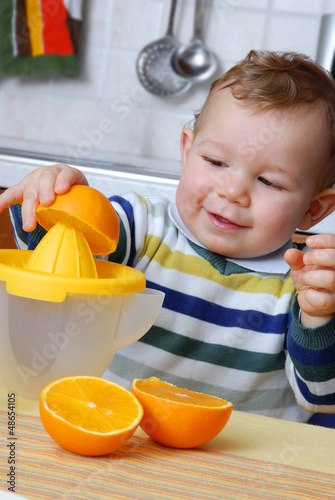 Photo: Pequeño niño exprimiendo jugo de naranja. Pequeño niño exprimiendo jugo de naranja.