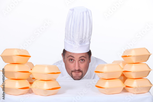 Photo: Chef with a pile of takeaway boxes Chef with a pile of takeaway boxes