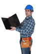 Tradesman looking at the underside of his laptop