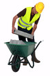 craftsman putting stones in a wheelbarrow