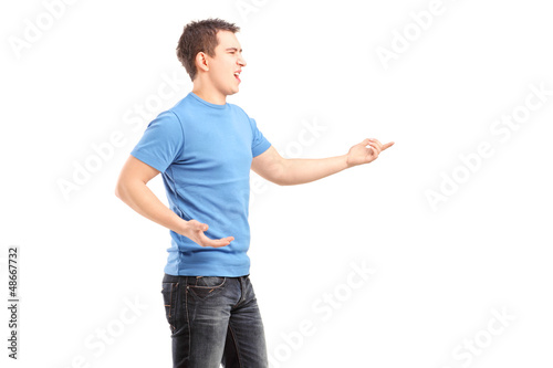 Photo: Young angry male pointing with finger Young angry male pointing with finger