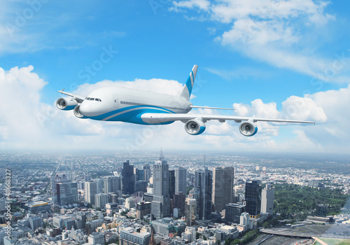 Photo: White passenger plane flying above a city White passenger plane flying above a city