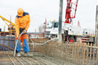 builder worker vibrating concrete in form