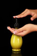 woman squeezing lotion on her hand, on black background