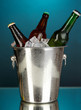Beer bottles in ice bucket on darck blue background