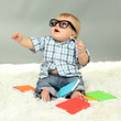 Little boy with multicolor books, on white carpet