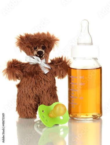 Photo: Baby bottle with fresh juice and teddy bear isolated on white Baby bottle with fresh juice and teddy bear isolated on white