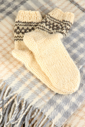 Photo: Warm knitted socks on plaid close-up Warm knitted socks on plaid close-up
