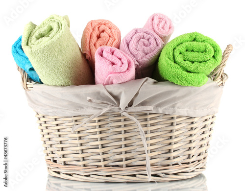 Photo: Colorful towels in basket isolated on white Colorful towels in basket isolated on white