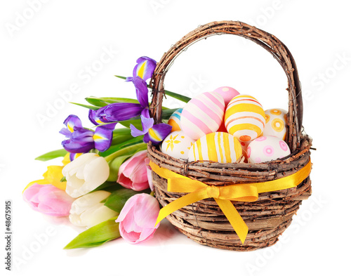 Photo: Easter eggs in a basket and spring flowers. Easter eggs in a basket and spring flowers.