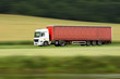 large red truck speeding on highway