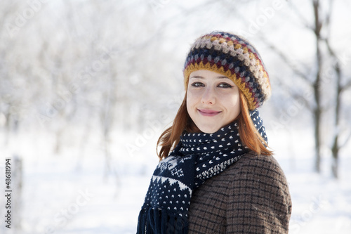 Photo: Beautiful young red-haired woman in winter park Beautiful young red-haired woman in winter park