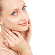 Cute woman applying cream to her face
