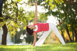 Pretty woman doing yoga exercises in the park