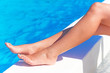 Foto: Sexy female legs at blue water of swimming pool Sexy female legs at blue water of swimming pool