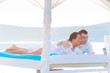 Couple lying on luxury white bed at the sea