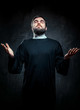 Portrait of priest against dark background
