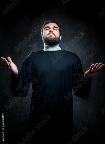 Photo: Portrait of priest against dark background Portrait of priest against dark background