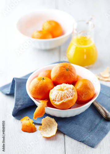 Photo: Mandarins in a bowl and a jug of mandarin juice in background Mandarins in a bowl and a jug of mandarin juice in background