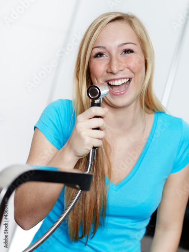 Photo: Young woman has fun at the kitchen sink with the tap Young woman has fun at the kitchen sink with the tap