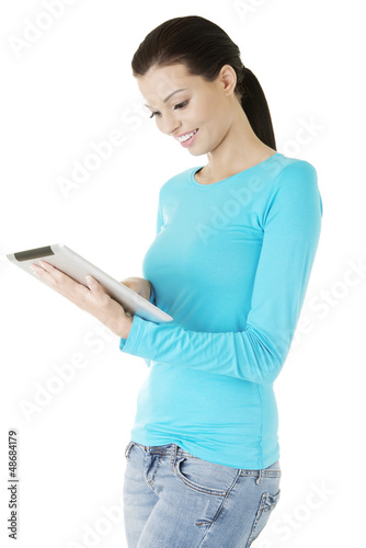 Photo: Young pretty woman working on tablet computer Young pretty woman working on tablet computer