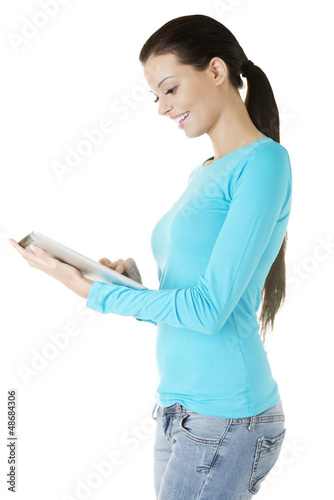 Photo: Young pretty woman working on tablet computer Young pretty woman working on tablet computer