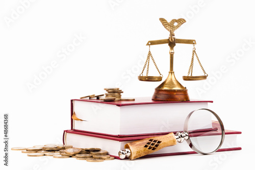 Photo: law books, money , magnifying glass and scales of justice law books, money , magnifying glass and scales of justice