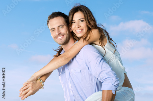 Photo: Young Man Carrying Woman On Back Young Man Carrying Woman On Back