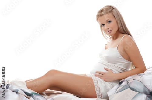 Photo: The pregnant woman sits isolated The pregnant woman sits isolated