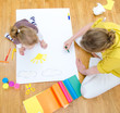 Young woman and little girl drawing. Top view