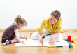 Photo: Young woman and little girl drawing together Young woman and little girl drawing together